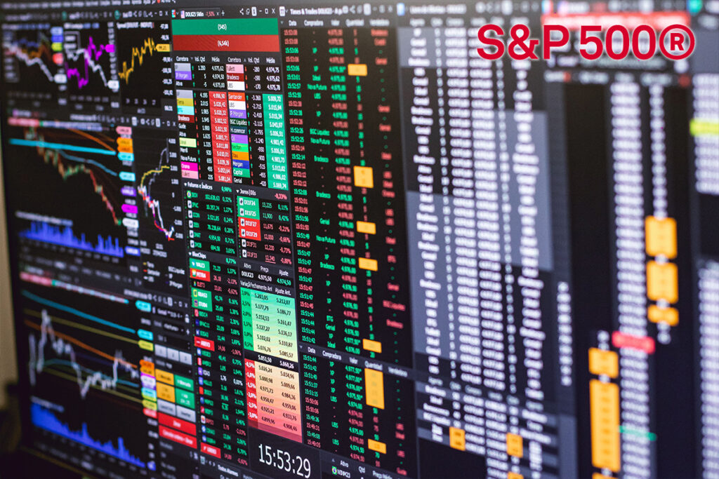 Multiple monitor screens showing colorful stock charts and market data with a prominent S&P 500® logo in red at the top right.